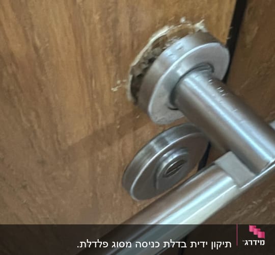 ידית דלת מתכתית עם נזק סביב המנעול